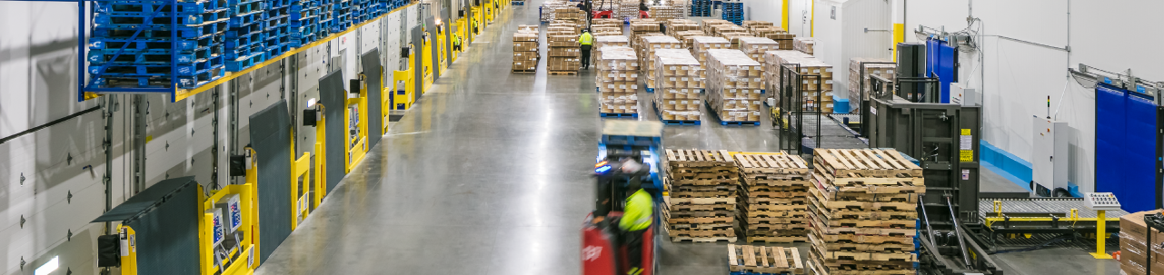 Industrial facility floor with shipping palettes and forklifts 